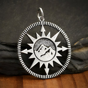 Sterling silver compass charm with mountain top design in the center