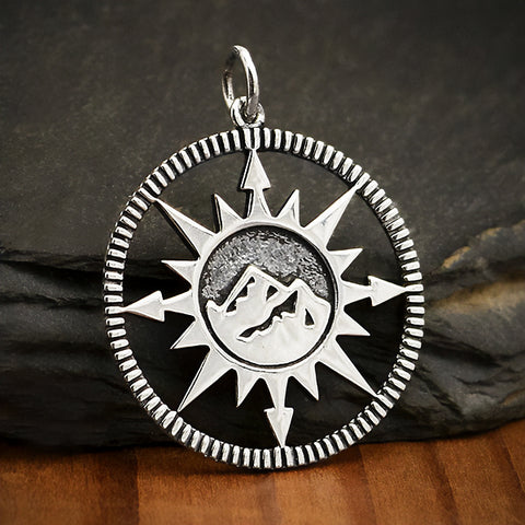 Sterling silver compass charm with mountain top design in the center